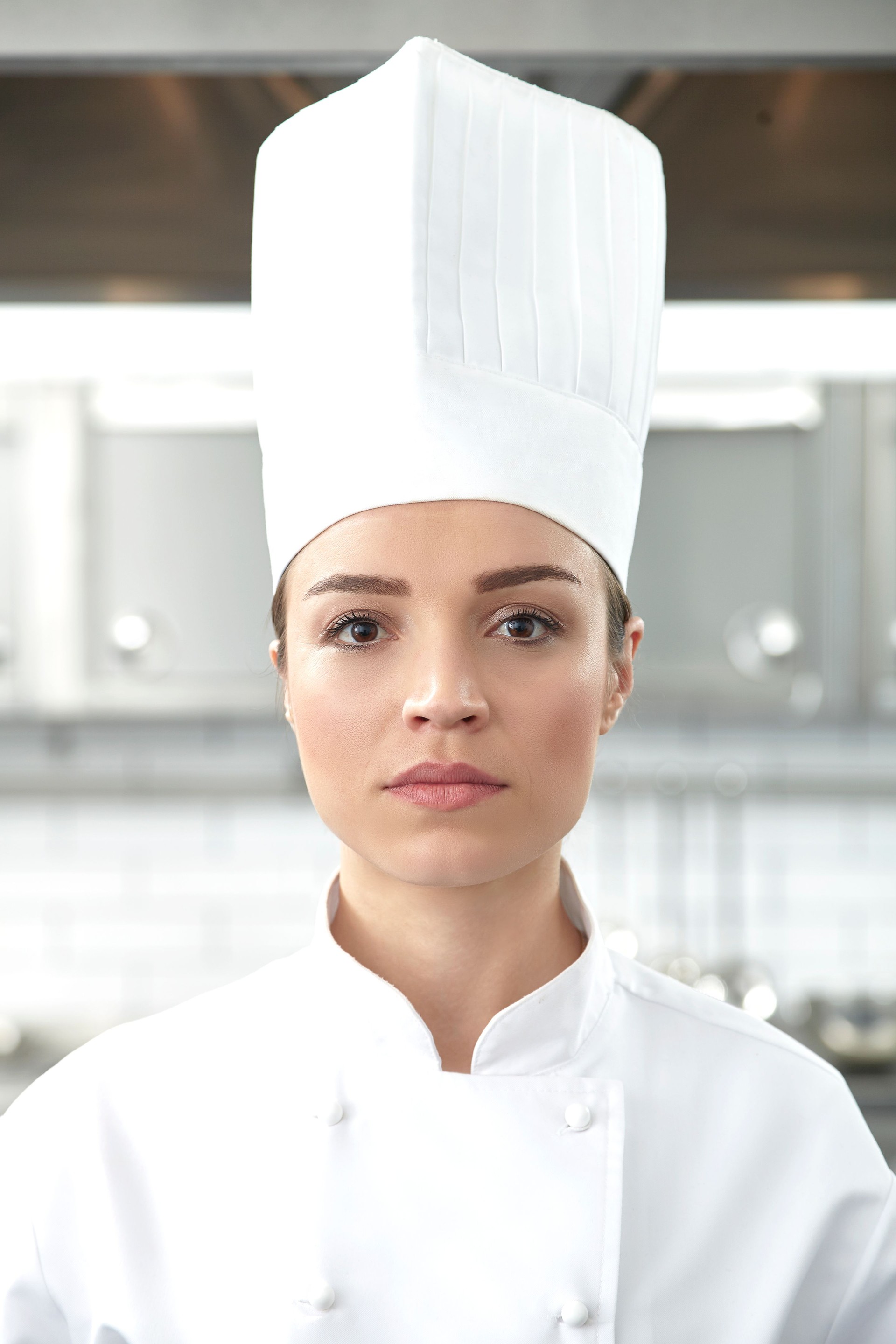 Serious female chef portrait in restaurant kitchen